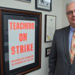 AFT Ed Allen in front of strike poster solidarity