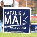Man pulling up campaign signs 2018-6-12