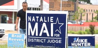 Man pulling up campaign signs 2018-6-12