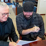 Okla City Free Press gains new leader as founder retires Brett Dickerson on left and Brett Fieldcamp on right look over the transfer of ownership of shares of Oklahoma City Free Press LLC on Monday, Feb. 9. (B.DICKERSON/Okla City Free Press)