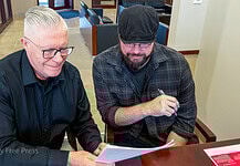 Brett Dickerson on left and Brett Fieldcamp on right look over the transfer of ownership of shares of Oklahoma City Free Press LLC on Monday, Feb. 9. (B.DICKERSON/Okla City Free Press)