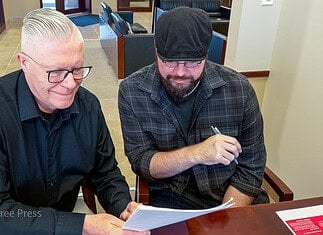 Brett Dickerson on left and Brett Fieldcamp on right look over the transfer of ownership of shares of Oklahoma City Free Press LLC on Monday, Feb. 9. (B.DICKERSON/Okla City Free Press)