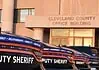 Cleveland County Sheriff resigns following embezzlement plea deal Row of black Dodge deputy sheriff patrol cars lined up in front of the Cleveland County Office Building exterior, displaying bold ‘DEPUTY SHERIFF’ lettering.