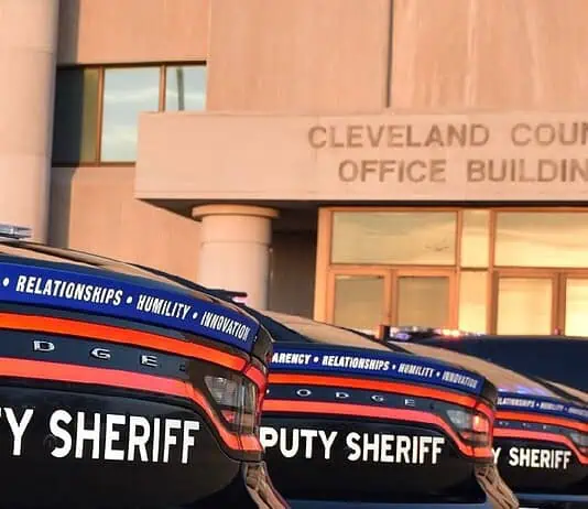 Cleveland County Sheriff resigns following embezzlement plea deal Row of black Dodge deputy sheriff patrol cars lined up in front of the Cleveland County Office Building exterior, displaying bold ‘DEPUTY SHERIFF’ lettering.