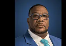 PRESS RELEASE: Metro Tech Board of Education appoints David Martin as Superintendent & CEO Portrait of a Black man in a blue suit, white shirt, and turquoise patterned tie, against a dark blue gradient background.