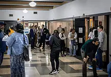Oklahoma’s eviction process is being used as a form of rent collection, data shows Diverse adults waiting in a hospital corridor, some talking near doors and seating area under bright lights in a medical facility.