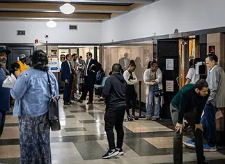 Oklahoma’s eviction process is being used as a form of rent collection, data shows Diverse adults waiting in a hospital corridor, some talking near doors and seating area under bright lights in a medical facility.