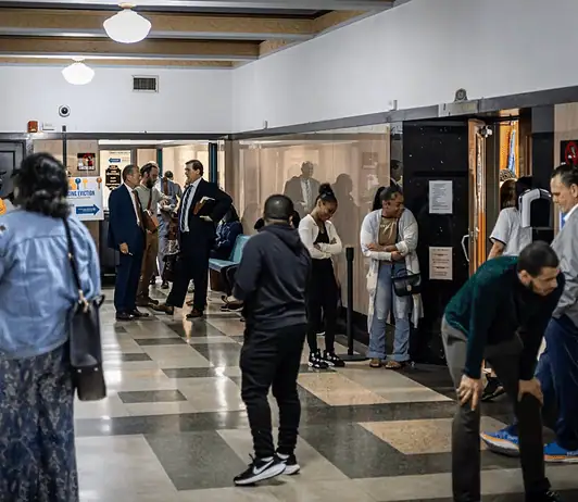 Oklahoma’s eviction process is being used as a form of rent collection, data shows Diverse adults waiting in a hospital corridor, some talking near doors and seating area under bright lights in a medical facility.