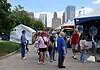 Festival of the Arts kicks off 60th year celebrating art in OKC People walk through an outdoor street fair with white tents and vendors, city skyscrapers in the background.
