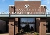 Entrance to Francis Institute Kay Martin Center: brick façade, glass doors, and landscaped planters under a clear blue sky.