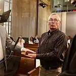 PRESS RELEASE: Brian Young sworn in as Oklahoma City Municipal Court judge Man in a gray suit raises his right hand to take an oath, as another man holds a book for him in a formal setting.