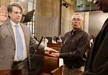 PRESS RELEASE: Brian Young sworn in as Oklahoma City Municipal Court judge Man in a gray suit raises his right hand to take an oath, as another man holds a book for him in a formal setting.