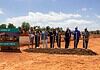 Groundbreaking ceremony for the Tom and Judy Love YMCA with people in hard hats holding shovels beside the sign.