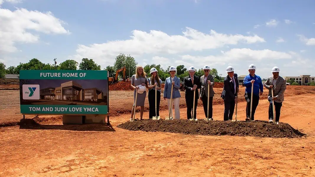 northside-groundbreaking2 Groundbreaking ceremony for the Tom and Judy Love YMCA with people in hard hats holding shovels beside the sign.