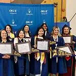 PRESS RELEASE: OKCPS Foundation celebrates 14 new Teacher Pipeline program graduates Group of graduates in blue gowns smiling and holding framed diplomas in front of a blue backdrop with OGE logos behind them.
