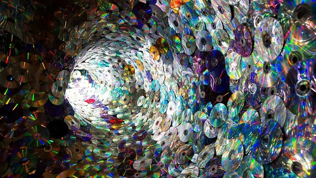 CD image of artwork Spiral tunnel made of stacked compact discs reflecting rainbow colors