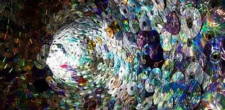 Spiral tunnel made of stacked compact discs reflecting rainbow colors
