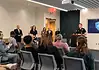 Lake Arcadia mass shooting victim dies; police provide few new answers Police officer at a podium addressing a seated audience in a briefing room, Edmond Police logo on a screen behind him.