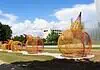 Massive ‘Formless Matter’ sculpture transforms OK Contemporary art park Outdoor art installation featuring large orange wire pumpkins on a curved concrete path in a park under a bright blue sky with white clouds.