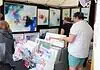 Paseo Arts Fest kicks off for a vibrant festival weekend Art market stall with vivid abstract paintings on the walls and a display of cards and prints; shoppers browse the artwork.