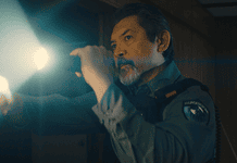 deadCenter features go heavy on history, diversity, modern battles Male officer in uniform shines a flashlight into a dim room, beam across the scene,
