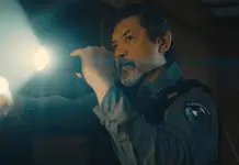 deadCenter features go heavy on history, diversity, modern battles Male officer in uniform shines a flashlight into a dim room, beam across the scene,