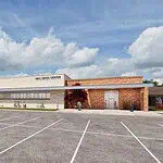 PRESS RELEASE: Plans for MAPS 4 Mental Health Crisis Center approved Exterior view of the OKC Crisis Center with a brick and tan facade and a spacious parking lot in the foreground, daytime with people walking nearby.