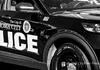 Black-and-white photo of an Oklahoma City Police Department patrol car with large POLICE lettering on the side.