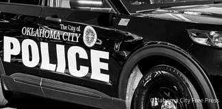 Black-and-white photo of an Oklahoma City Police Department patrol car with large POLICE lettering on the side.