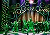 ‘The Wiz’ a magical, musical, cultural celebration at Civic Center Stage with neon-green 1920s signage and palm-leaf motifs; a group of dancers in green costumes perform a choreographed routine.