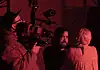 deadCenter shorts shine light on humanity, redemption, imagination Cameraman operating a large professional camera while a man and woman converse in a red-lit studio space.