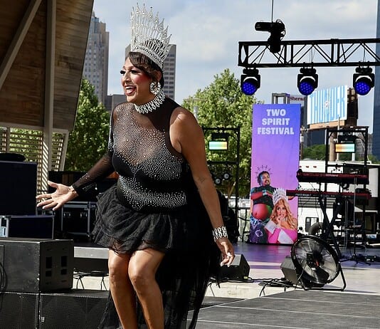 PrideFest 2026 kicks off with joy, community at Scissortail Park Drag performer wearing a tall silver crown and black sequined outfit performing on an outdoor stage at the Two Spirit Festival