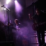 Crank up the summer with these hard-driving rock and metal shows Live music performance on a foggy stage with purple lighting; female singer left, keyboardist center, guitarist right.