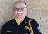 PRESS RELEASE: Francis Tuttle instructor named regional Teacher of the Year Older male sheriff in uniform smiling against a brick wall, with gold braid and badge.