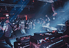 Showcases, mini-fests lift energy, noise, next generation of OKC music Band performs on stage in a crowded club, guitarist at left, drummer on the right, blue and red stage lights illuminating the audience.