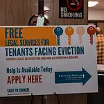 OKC evictions have doubled in a decade Poster offering free legal services for tenants facing eviction in a hallway; no smoking sign above and people in the background.