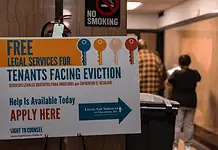 OKC evictions have doubled in a decade Poster offering free legal services for tenants facing eviction in a hallway; no smoking sign above and people in the background.