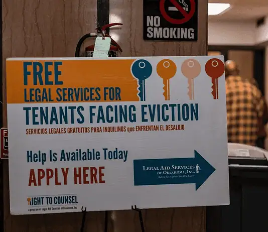 OKC evictions have doubled in a decade Poster offering free legal services for tenants facing eviction in a hallway; no smoking sign above and people in the background.