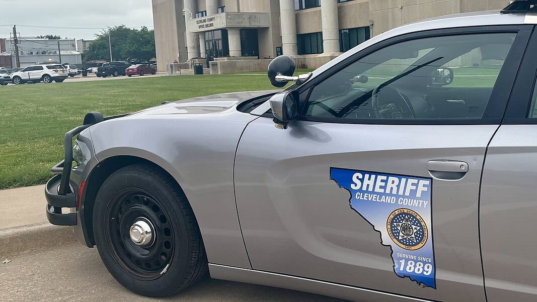 Photo Jun 12 2026, 11 25 19 AM Side of a silver sheriff patrol car with a Cleveland County badge and an Ohio-shaped decal reading 'Serving since 1889'.