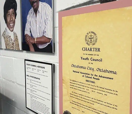 Freedom Center unveils restoration with ‘Inside These Walls’ exhibition Wall exhibit with four large portraits of diverse adults, plus a yellow CHARTER poster labeled 'Youth Council' on a pink mat, and a framed council advisory list nearby, in a museum-like setting.