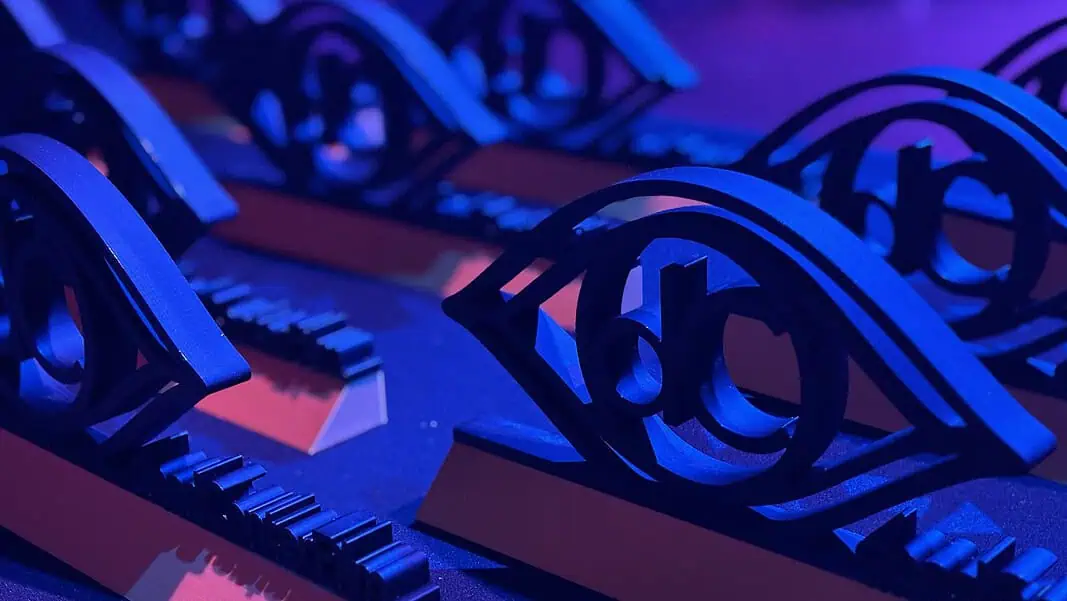 Photo Jun 13 2026, 6 57 43 PM Close-up of ornate black metal eye-shaped sculptures resting on a keyboard, lit in blue and purple stage lighting.