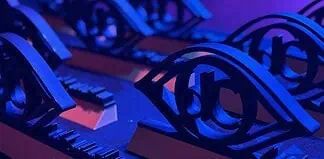 Close-up of ornate black metal eye-shaped sculptures resting on a keyboard, lit in blue and purple stage lighting.