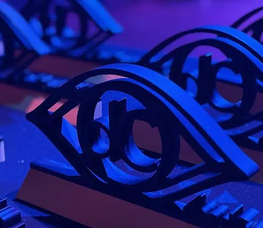 Here are the award winners of the 2026 deadCenter Film Festival! Close-up of ornate black metal eye-shaped sculptures resting on a keyboard, lit in blue and purple stage lighting.