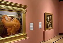 OKCMOA welcomes breadth, beauty of art from famed Puerto Rican museum Large ornate gold-framed painting on a pink wall, depicting a woman in an orange dress resting; to its right, a smaller framed religious-style artwork on a pedestal, also on pink wall.