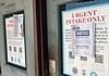 A door with a large posting labeled 'URGENT INTAKE ONLY' and a smaller 'NOTICE' sign attached over the poster.