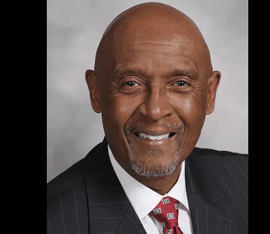 PRESS RELEASE: OKC honors the life of M.T. Berry, first Black police chief Professional headshot of a smiling Black man in a dark pinstripe suit and red patterned tie, against a gray backdrop.