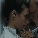 Hypnotic, unsettling ‘Night Nurse’ a piercing portrait of sociopathy Young woman and an older man press foreheads together in a tender, intimate moment beside a wall.