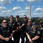 OKC police in DC: Dept says no concern or cost to public at home Group of police officers posing for a photo on a boat or dock with the Washington Monument in the background along the Potomac River