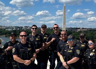 OKC police in DC: Dept says no concern or cost to public at home Group of police officers posing for a photo on a boat or dock with the Washington Monument in the background along the Potomac River
