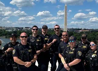 OKC police in DC: Dept says no concern or cost to public at home Group of police officers posing for a photo on a boat or dock with the Washington Monument in the background along the Potomac River